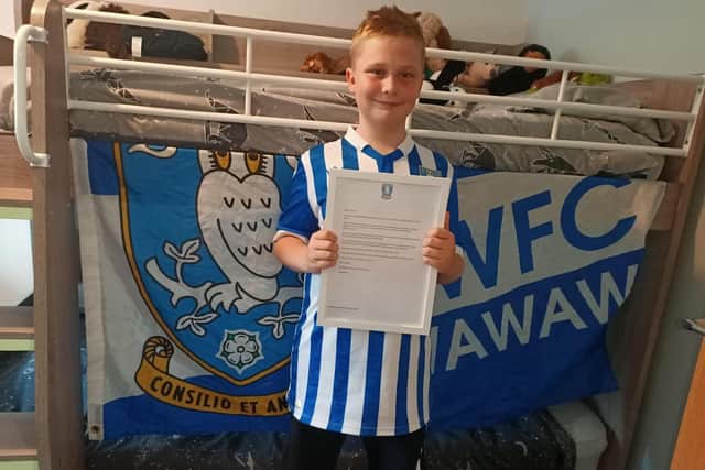 Sheffield Wednesday fan Joshua Lazenby, nine, stands proudly with the letter sent to him by the club for standing up to bullies.
