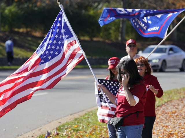 Supporters of President Donald Trump wave signs and flags at the entrance to Trump National golf club in Sterling, Va., Saturday Nov 7, 2020. He was at the facility. (AP Photo/Steve Helber)