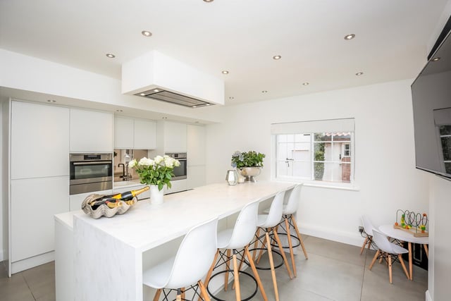 An "impressive, modern kitchen" fitted with an extensive range of floor to ceiling units with integrated appliances including larder fridge, freezer, steam oven, fan oven and warming drawer.