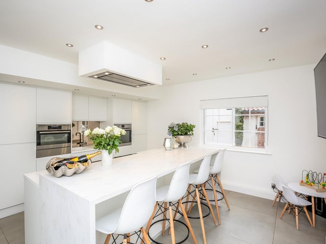 An "impressive, modern kitchen" fitted with an extensive range of floor to ceiling units with integrated appliances including larder fridge, freezer, steam oven, fan oven and warming drawer.