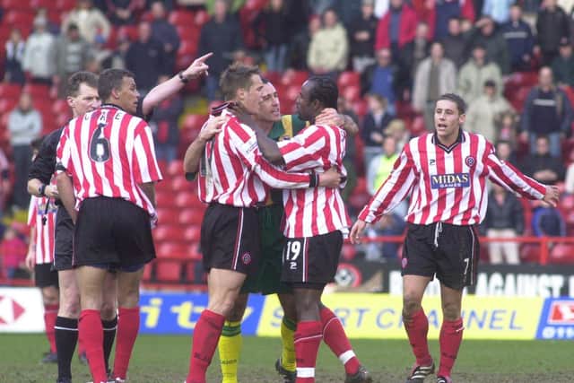 Sheffield United's Patrick Suffo is held back by players after being sent off by referee Eddie Wolstenholme during the Battle of the Bramall Lane against West Bromwich Albion in March 2002.