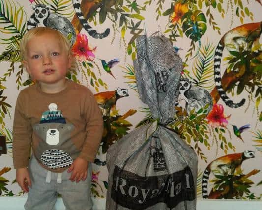 Toby Duxbury at 30 months with a bulging Post Office delivery.