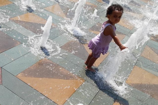 A youngster cools off in the fountains