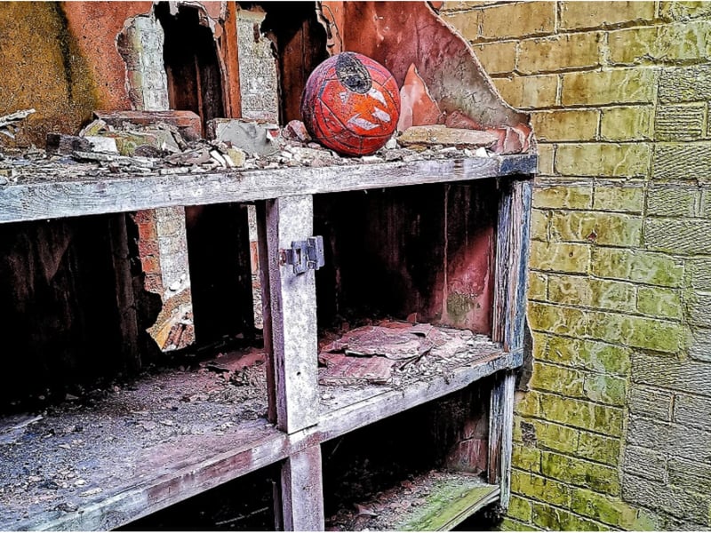 A football lies unused among the ruins.