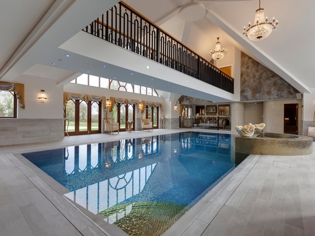 The swimming pool forms part of the property’s spa complex, which includes an indoor heated pool, Jacuzzi, sauna, relaxation area, shower rooms and a suspended walkway above the pool which leads to a treatment room.
