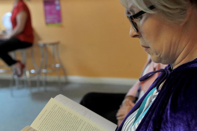 Teaching assistant Jan Burton follows the words as she listens to the reading of JK Rowling.