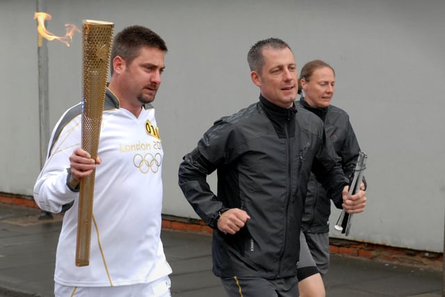 Olympic Torch bearer Andrew Moore carries the flame towards South Shields Town Hall.