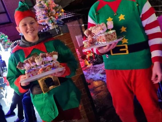 Elliott and Liam Green as Santa's elves in front of the amazing Christmas lights display on Lyons Street in Pitsmoor, Sheffield, which was created to raise money for The Sick Children's Trust