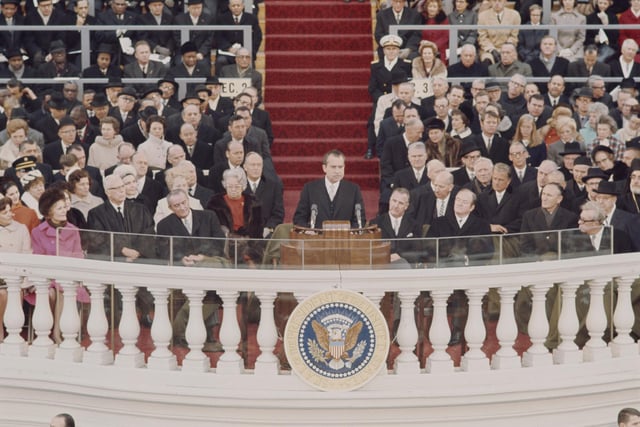 Recently elected 37th President of the United States, Richard Nixon (1913-1994) delivers his inaugural speech from a podium during the inauguration ceremony in front of the Capitol in Washington D.C. on 20th January 1969. Outgoing President Lyndon Johnson is seated to the left of President Nixon. (Photo by Rolls Press/Popperfoto via Getty Images/Getty Images) 