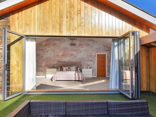The master bedroom enjoys a vaulted ceiling and bi-folding doors onto the large and well-screened private terrace offering excellent views over the garden and beyond.