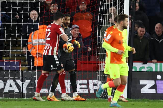 John Egan of Sheffield United congratulates Wes Foderingham following his penalty save from Brennan Johnson of Nottingham Forest: Darren Staples / Sportimage