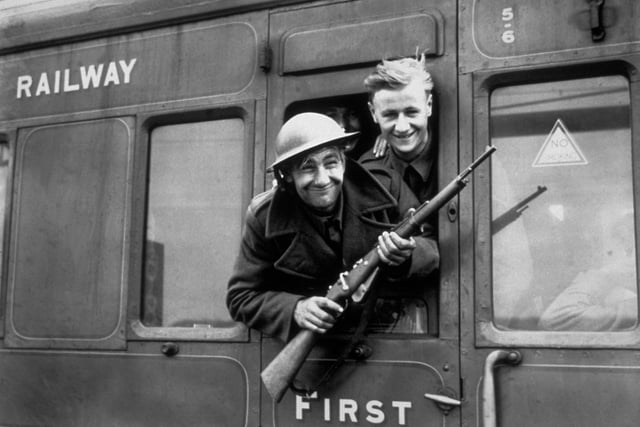 1940:  Troops continue to arrive home in their thousands following the rescue of the British Expeditionary Forces at Dunkirk. This member of the BEF has brought a German rifle home as a souvenir.  (Photo by Parker/Fox Photos/Getty Images)