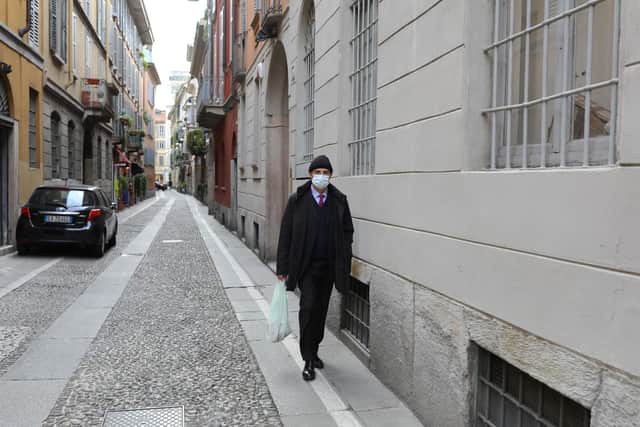 A man wearing a mask walks on an empty street in the Brera Neighborhood (Photo by Marco Di Lauro/Getty Images)