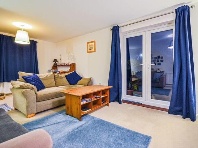 As you enter the property, a spacious hallway leads to this large living room. It oozes comfort and style and boasts French doors that guide you into the garden.