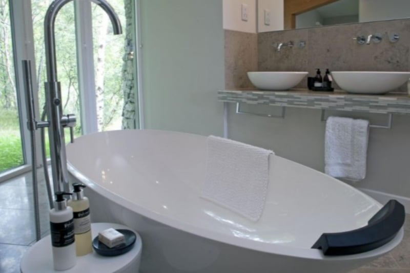 The bathroom in Curved Stone House features a stunning free-standing bath.