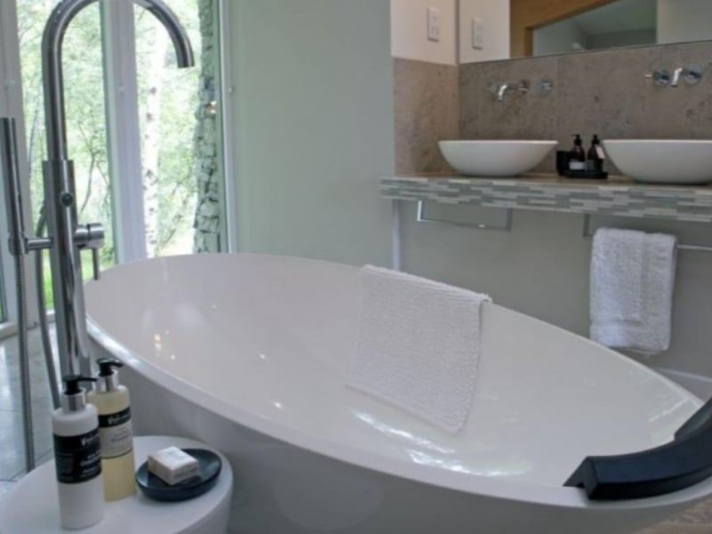 The bathroom in Curved Stone House features a stunning free-standing bath.
