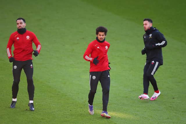His good form earned Ndiaye, pictured here warming up with Kean Bryan and George Baldock, a senior call-up: Simon Bellis/Sportimage