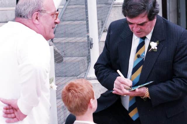 Cricketer Freddie Trueman signs his autograph for at young fan at the Yorkshire Day celebrations at Don Valley Stadium on August 1, 1993