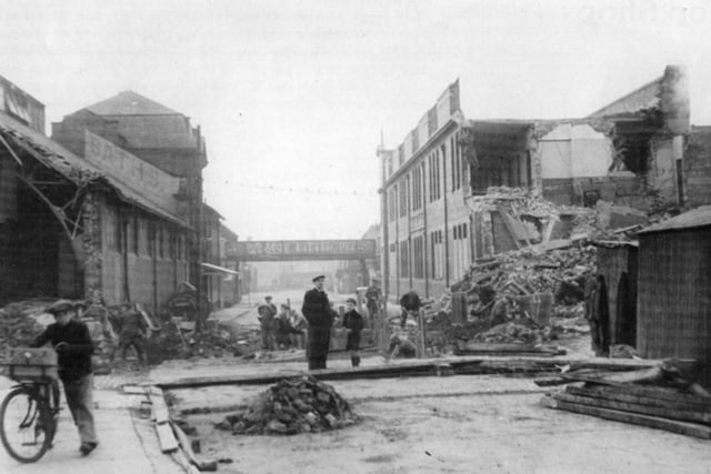Surveying the ruins from an air raid on Derby Street in 1941, but locals still went on with their business.