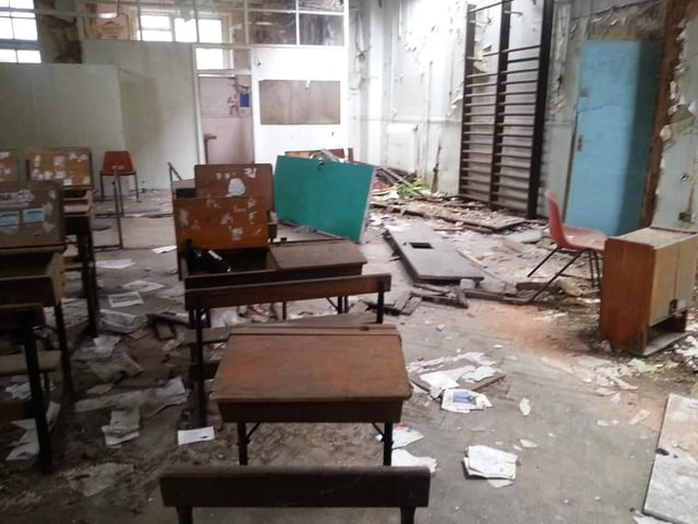 Old-fashioned desks and paperwork scattered all over the floor. Did you sit here?