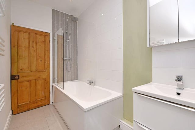 The main bathroom has a white suite with a shower over the bath with a glass screen, a wash basin, WC, and fashionable tiling. There's also a separate WC with Farrow & Ball decor, and a shower room on the second floor.
