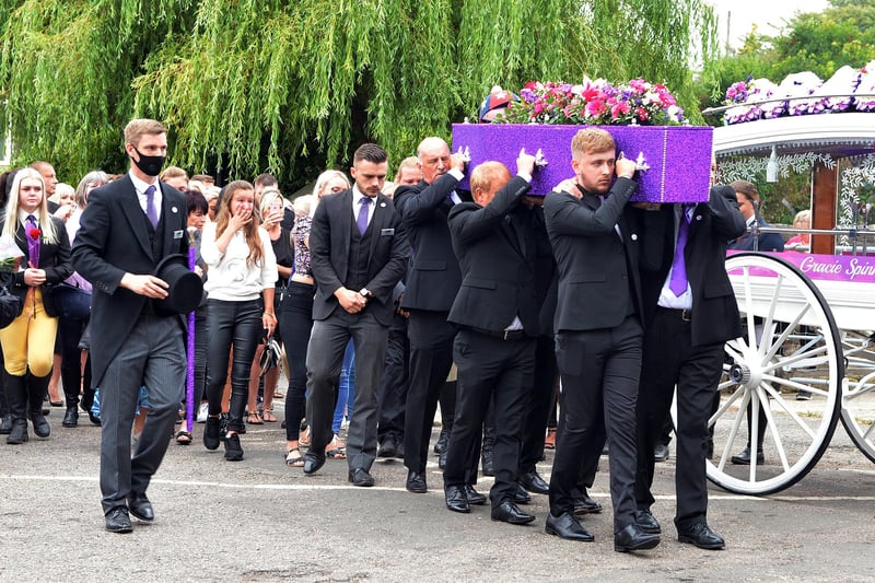 Gracie's beautiful purple coffin is carried into the church.