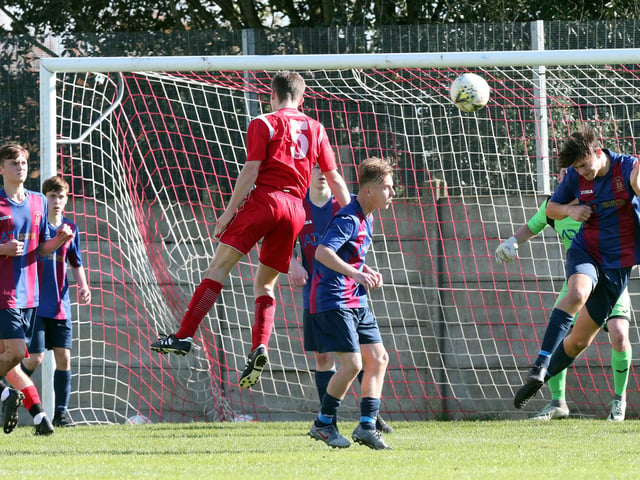 Horndean's Harry Webb (5) gets in a header at the US Portsmouth goal. Picture: Chris Moorhouse