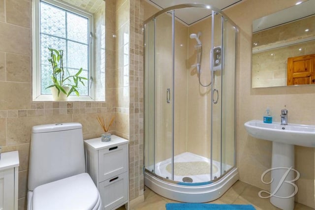 An enclosed shower is the highlight of the upstairs bathroom, which also features a low-flush WC, a pedestal sink and tiled flooring. There is also a WC downstairs.