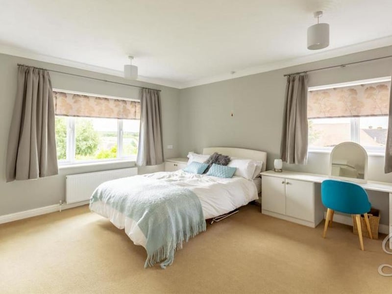 Upstairs to the first bedroom, which has fitted wardrobes and units, and a carpeted floor. There are dual-aspect windows and two central-heating radiators.