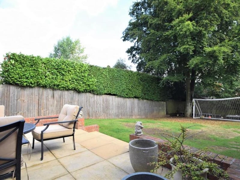Just beyond the patio area is this back garden. The lawn is an ideal play area, in view of the house and secured by a surrounding fence.