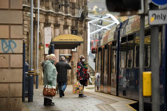 Commuters wear face masks as they wait at a tram stop in Sheffield (Photo by Oli SCARFF / AFP) (Photo by OLI SCARFF/AFP via Getty Images)