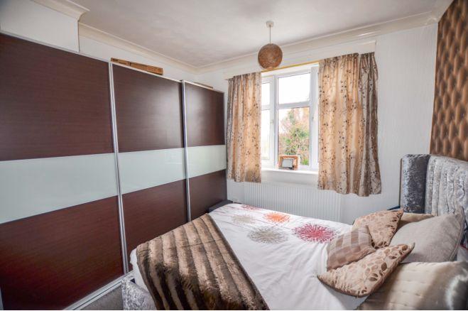 This bedroom has built in wardrobes and coving to the ceiling. The window overlooks the back garden.