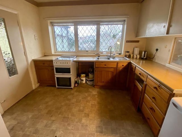 Here is the bungalow's kitchen, which has wall and base units, with worktops over, incorporating a one-and-a-half bowl sink drainer and mixer tap, an electric cooker and radiator.
A door leads to the hallway, while there is a uPVC window to the back of the property.