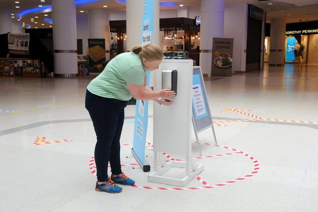 Mhairi Joyce from Portsmouth, using the hand sanitisers provided in Cascades Shopping Centre. Picture: Sarah Standing (150620-9800)