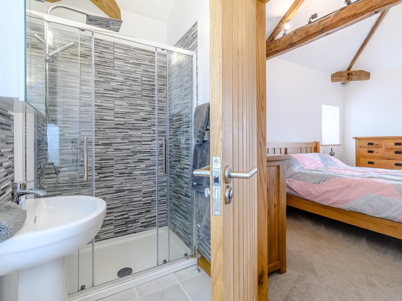 This bedroom is en-suite, complete with a walk-in shower. Another example of the very high standards at Warren Farm Stables.