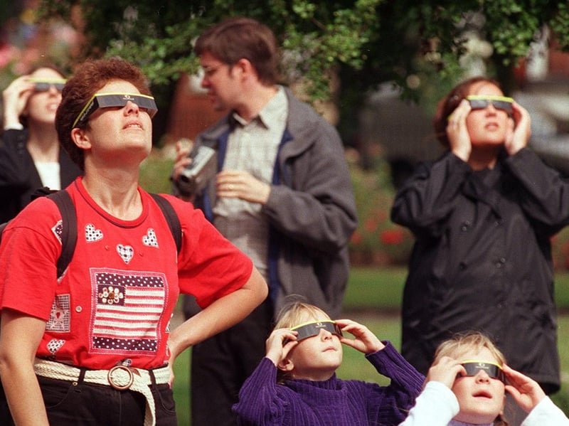Equipped with protective solar eclipse viewing glasses, crowds in Park Square look up as the Sun is obscured over West Yorkshire in 1999.