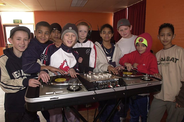 Hopeful DJs gather round the decks as part of a DJ workshop at Park Hill Community Centre in Sheffield in February 2003