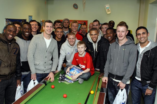 Chesterfield players visit poorly children in Chesterfield Royal Hospital to hand out goodie bags in 201. Tyler Dixon, aged 13, is surrounded by the team.