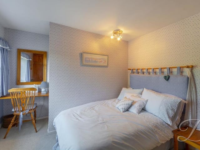 Another of the four versatile bedrooms. It has a carpeted floor, fitted wardrobes, central-heating radiators and a window.