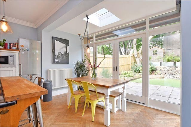 The dining area has a roof light and French doors leading to the garden.