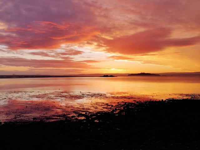 The sky cast its picturesque and delicate colours of pink, yellow and orange across this Fife beach's seascape.