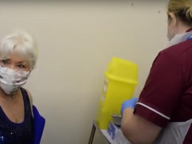 Healthcare assistant Melissa Kydd gets ready to immunise Jeannette Adams