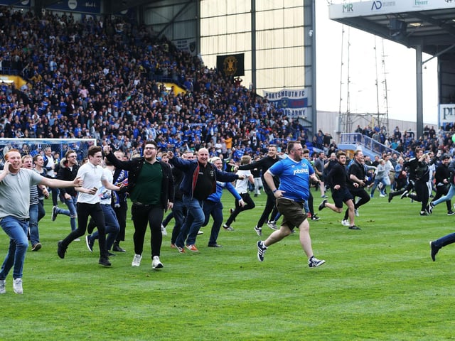 Fans invade the Fratton Park pitch.