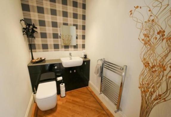 The downstairs wc and cloackroom has a white suite comprising low level wc, pedestal basin with tiled splashback, Karndean flooring, radiator and extractor fan.