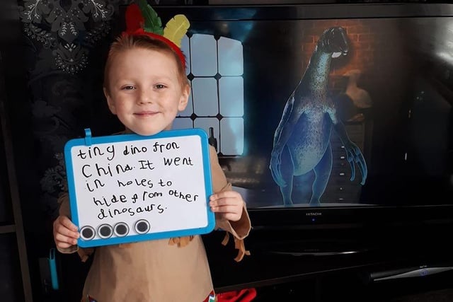 Henry, five, proudly holds his research on dinsosaurs.