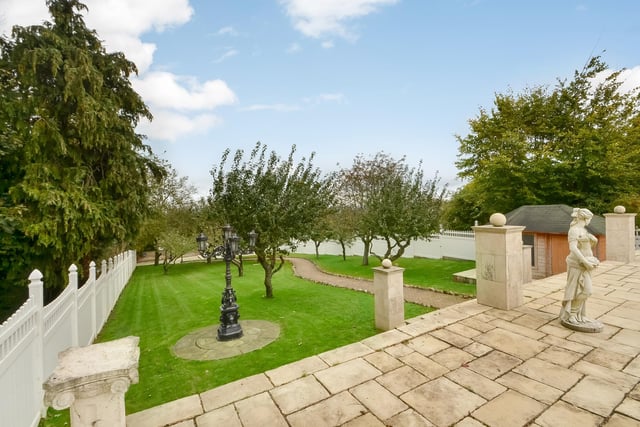 This huge five-bedroom Portsdown Hill home in Portsmouth is up for raffle. Pictured is its garden and the path to its indoor pool and annex.
