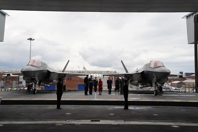 Queen Elizabeth II (centre) going on to the flight deck, with a pair of F-35B Lightning II aircraft on either side, during a visit to HMS Queen Elizabeth at HM Naval Base, Portsmouth, ahead of the ship's maiden deployment. The visit comes as HMS Queen Elizabeth prepares to lead the UK Carrier Strike Group on a 28-week operational deployment travelling over 26,000 nautical miles from the Mediterranean to the Philippine Sea. Picture date: Saturday May 22, 2021. PA Photo. See PA story ROYAL Carrier. Photo credit should read: Steve Parsons/PA Wire