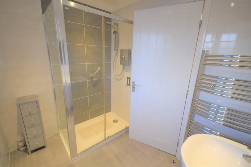 A good sized contemporary suite with matching wall and floor tiles, corner shower cubicle and Aqualisa shower, wc, wash hand basin, shaver point, chrome towel rail, downlights to the ceiling and double glazed obscure window.