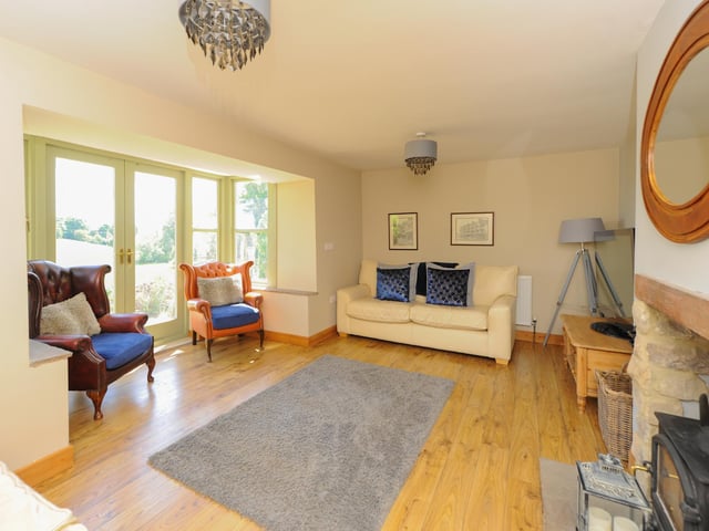 The lounge has a spacious bay window and a wood burning stove.