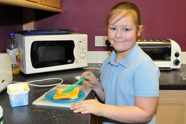 Owton Manor Primary School pupil Casey Wilson is pictured buttering her toast at the breakfast club.